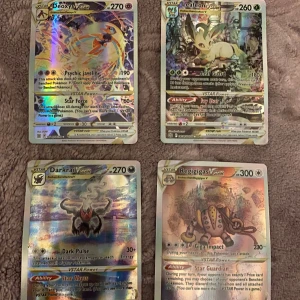 Pokémon VSTAR-kort - Säljer fyra Pokémon VSTAR-kort: Deoxys, Leafeon, Darkrai och Regigigas. Dessa kort har holografisk design och är perfekta för samlare eller spelare som vill förstärka sin kortlek. Varje kort har unika förmågor och attacker som kan användas i spelet.