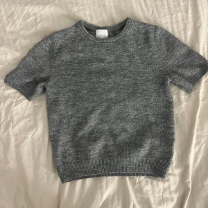 Grå stickad tröja - Säljer en stilren grå stickad tröja med korta ärmar i storlek Xs. Använd fåtal gånger