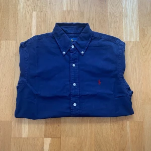 Ralph Lauren skjorta  - En mörkblå skjorta från Ralph lauren i storlek S men passar mer som M eftersom den är stor på mig som är 176 och väger 62 kg och passar perfekt på någon som är mellan 180-188 cm lång.