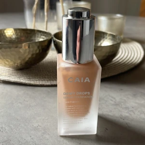 Dewy Drops Serum Foundation från CAIA - Säljer en Dewy Drops Serum Foundation från CAIA i nyansen 30W. Denna foundation ger en fräsch och strålande finish med en lätt och återfuktande formula. Perfekt för en naturlig look.