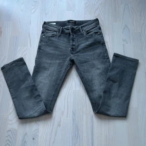 Jack and jones jeans - Saljes: En Jack & Jones jeans i klassisk grå. Denna jeans är det perfekta valet för dig som vill ha en stilren och tidlös look med en touch av lyx. Storleken är 30/32.   Detaljer: • Marke: Jack & Jones • Farg: grå • Storlek: 30/32 • Skick: 10/10 