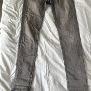 Grå jeans från House of Lola - Snygga grå jeansbyxor med en klassisk femficksdesign. De har en knapp och dragkedja framtill. Medelhög midja. Inte så mycket stretch. Jag är 1,63 och de räcker ner till hälen.