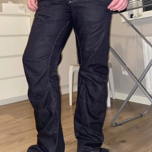 Svarta byxor från Jack and Jones - Snygga svarta Lågmidjade byxor från Jack and Jones med klassisk design. Byxorna har fickor med knappdetaljer och en bekväm passform. De är bootcut skulle jag säga.