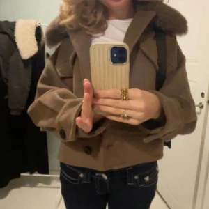 Brun Meotine Jacka - Säljer en snygg brun jacka från Meotine med en lyxig pälsdetalj på kragen. Jackan har stora fickor med knappar, en av knapparna har tyvärr gått av men det inget som alls tänker på vid användning❤️❤️storlek M/L fast skulle säga att den mer är M. Pris är diskuterbart! (bild 1 & 2 är lånade)