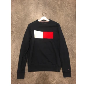Helt Ny  Tommy Hilfiger strl S  - Säljer en svart tröja från Tommy Hilfiger med ett stort färgblock i vitt och rött på framsidan. Tröjan har långa ärmar och ribbade muddar vid ärmslut och nederkant. Perfekt för en stilren och avslappnad look Endast provad sonen tyckte inte om den . Kommer från Djur och Rökfritt Hem 