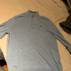 Ljusblå Morris tröja med dragkedja - Säljer en stilren ljusblå Morris tröja i storlek L men som sitter som S! Tröjan är använd 3 gånger och tvättad där den krympte, så tröjan är så gott som ny