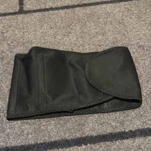 Svart bälte - Snyggt svart bälte i ett enkelt och stilrent utförande. Perfekt för att komplettera din outfit med en diskret touch. Bältet har en slät yta och är lätt att matcha med olika kläder.