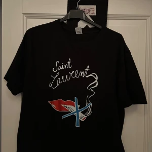 Saint Laurent T-shirt - Säljer min galet snygga och eftertraktade t shirt från Saint Laurent✨storlek M. Skick 9,5/10 som ny. Hör av er vid frågor och funderingar! Pris kan variera vid snabb och smidig affär