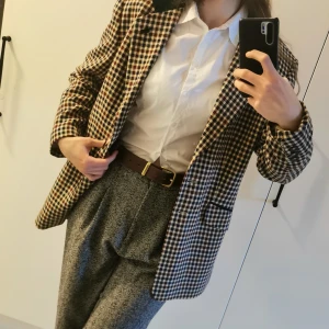 Rutig Kavaj - Rutig Kavaj/blazer från märket Gerry weber i tweedliknande material. Stilig och skön. Passar perfekt nu till våren. Längd:80cm. Bredd:45cm. Armlängd: 60cm.