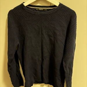 Mörkblå tröja från Jack & Jones - Säljer en stilren mörkblå tröja från Jack & Jones Premium. Tröjan har en diskret textur och rund halsringning. Perfekt för en avslappnad och snygg look. Passar bra till både jeans och chinos.