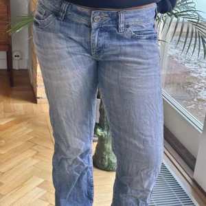 Blå jeans med bootcut - Snygga blå jeans med bootcut-stil och låg midja. Perfekta för en avslappnad look. Klassisk femficksdesign och knappgylf. Lite skrynkliga på bilden men dom är utsvängda men det syns ej pga skorna💕
