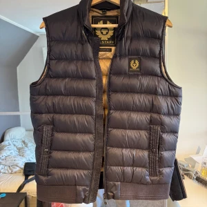 Mörkblå väst från Belstaff - Mörkblå dunväst från Belstaff i mycket bra skick. Stl är 46. Skulle säga att den sitter som S/M. Nypris 3800.