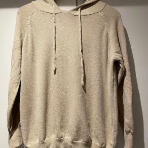 Beige merinoull hoodie - Säljer en stilren beige hoodie med långa ärmar och justerbar huva. Perfekt för en avslappnad look. Väldigt inne just nu. Är för liten för mig så har aldrig använts. 