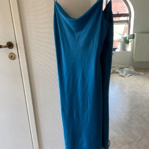 Blå klänning från Frakment - Snygg blå klänning från Frakment med smala axelband och en elegant, enkel design. Perfekt för en stilren look. Klänningen har en mjuk och följsam passform som ger en bekväm känsla. Formar sig otroligt fint på kroppen! Nypris ca 900kr. Oanvänd.