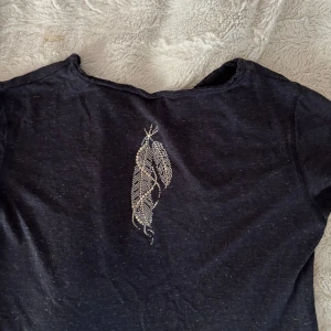 Zadig T-shirt  - Fin T-shirt från Zadig & Voltaire, osäker på storlek men sitter som en ganska liten xs. Lite glittrig i tyget och svart blå grå färg typ, den har en super fin fjäder på ryggen. Jätte skönt material💗💗