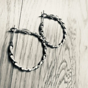 By prisförslag- 1 par Tvinnade silverörhängen medium size  - Snygga tvinnade örhängen i silver. Dessa hoops har en elegant design med en vriden struktur som ger en unik touch. Perfekta för att lyfta vilken outfit som helst.