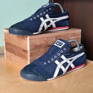 Blå sneakers från Onitsuka Tiger - Säljer ett par snygga blå sneakers från Onitsuka Tiger. Storlek 42,5 men kan användas mellan 41-43 eftersom de är väldigt tunna. Snören finns till också. Använda men i väldigt bra skick. Tveka inte att höra av er vid frågor:)