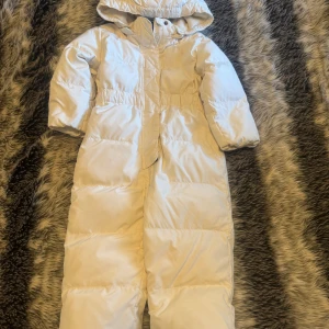 Vit overall från Ralph Lauren - Säljer en superfin vit dunjacka från Ralph Lauren för barn, storlek 2 år. Jackan är långärmad och har en mysig huva för extra värme. Perfekt för kalla vinterdagar! Den är i nyskick och redo för nya äventyr. 🧥❄️I bra skick💗Var ganska dyr när jag köpte🌸