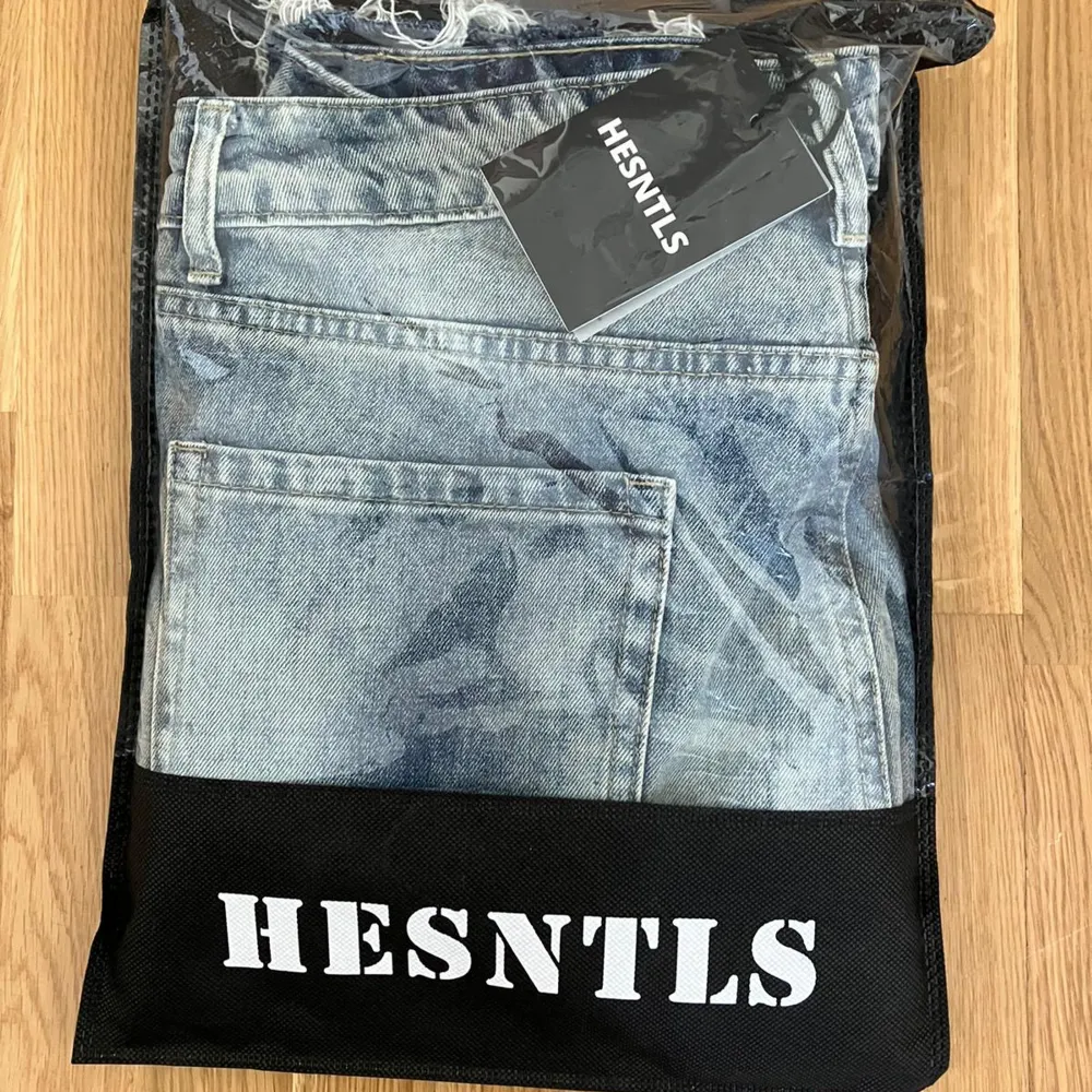 Säljer ett par snygga ljusblå jeans från HESNTLS. De har en cool, sliten look med ljusa detaljer och en rak passform. Perfekta för en avslappnad stil, oavsett om du ska på stan eller hänga med kompisar. Jeansen är tillverkade i ett bekvämt denim-material som gör dem både stiliga och sköna att bära.. Jeans & Byxor.