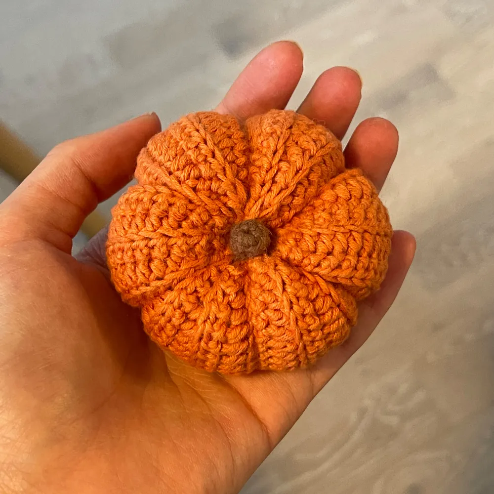 En superfin handgjord virkad pumpa i en härlig orange färg. Perfekt som dekoration till hösten eller Halloween! Den är liten och söt, ungefär lika stor som en handflata, och har en brun liten knopp på toppen. Passar perfekt som en mysig detalj i hemmet.. Accessoarer.