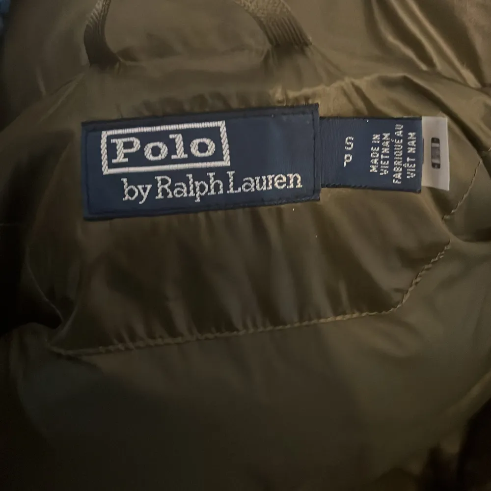 Säljer en snygg och varm grön pufferjacka från Polo Ralph Lauren. Jackan har en glansig yta och är perfekt för kalla dagar. Den har en dragkedja framtill och två praktiska fickor med dragkedjor. Perfekt för vintern! 🧥hör av er vid frågor!. Jackor.