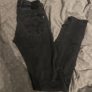 Replay jeans  - Säljer ett par riktigt snygga och trendiga replay jeans som är mörkgrå, byxorna är i ett super bra skick och är inte använda mycket alls, perfekt för dig som vill ha trendiga och stiliga jeans till ett bra pris, ny pris 1800kr köpta i somras!