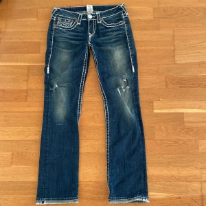 True religion jeans - Ett par snygga true religion jeans i storlek 28 lite slitna på benen och där nere den kanten där ner går inte och vila ner.skriv för mer information.Skriva innan du köper så de inte blir strul 