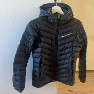 Peak Performance jacka  - Säljer min svarta tunna Peak jacka i storlek XS. Modellen W Frost Down Hood. Den är för liten för mig, men inga skador och fint skick.