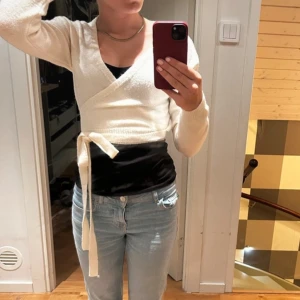 Vit omlottopp - Säljer en superfin vit omlottopp med knytband i midjan. Den är långärmad och perfekt för både vardag och fest. Toppen är i ett mjukt och bekvämt material! Köpt på vinted (lånad bild)💕 skriv för frågor