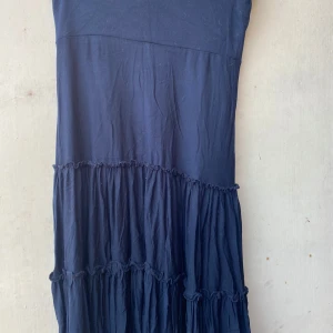Mörkblå klänning från Eve - Säljer en superfin svart kjol från Eve. Den har en härlig volangdetalj som ger den ett extra lyft. Perfekt för sommarens fester eller en dag på stan. Kjolen är i storlek S och sitter bekvämt.