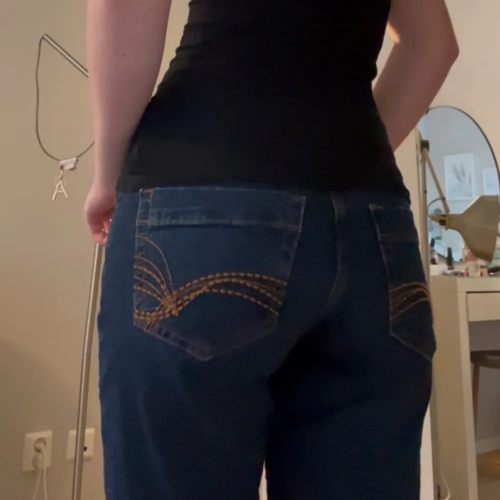 Mörkblå Lågmidjade bootcut jeans med orange/bruna sömmar med snygga detaljer på bakfickorna! Aldrig använda bara provade. Säljer för de tyvärr inte kommit till användning 💞💞💞 helt slutsålda i storleken på hemsidan . Jeans & Byxor.