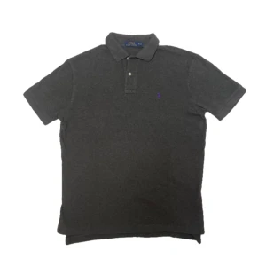 Grå Polo Ralph Lauren piké  - Snygg grå Ralph Lauren piké i grå med lila logga den är i mycket fint skick och i storlek M passar den även L och S beroende på hur man vill att den ska passa fråga gärna om extra bilder eller kom med prisförslag 👍