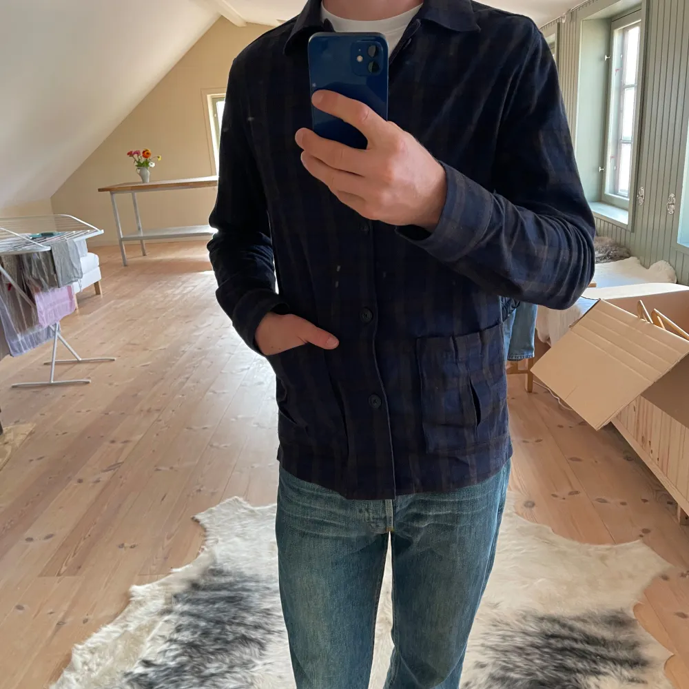 John Henric overshirt i flannel mönster.  Bra skick bortsett från en knapp som fattas i uppknäppningen av overshirten men det spelar inte en särskilt stor roll. Storlek m. Modellen är 182 cm och 72 kg. Hör av dig om funderingar och extra bilder. . Skjortor.