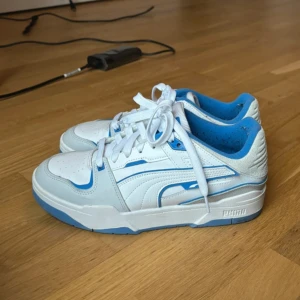 Puma sneakers 41 - Fräsha vita/blåa puma sneakers i storlek 41 dam. Jättefint skick, lite nopprigt i hälen men absolut inget slitet. Endast använd fåtal gånger