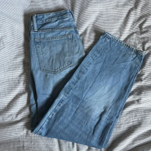 Blå jeansbyxor med dragkedja - Snygga blå jeansbyxor med klassisk femficksdesign och dragkedja. De har en rak passform och är perfekta för en avslappnad stil. Byxorna har en ljus tvätt som ger en vintagekänsla.