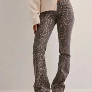  leopardmönstrade byxor - Snygga grå byxor med leopardmönster och bootcut-stil. Dom är lågmidja och storlek 34 använd 1 gång . Nypris är 700kr från Nelly 
