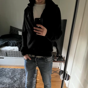 Cardigan från j Lindeberg  - Säljer en svart jacka med huva och dragkedja. Jackan har en kombination av material med quiltade detaljer på bröstet och en mjukare textur på resten. Perfekt för en casual look. Riktigt fet cardigan från j lindeberg som inte säljs längre. Toppskick. Fast pris, endast seriösa köpare.