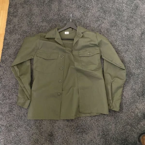Vintage army overshirt - Olivgrön vintage army overshirt köpt på herr judit i Stockholm. Storlek M. Hör av dig vid minsta fundering! Ifall du vill ha bild med den på är det bara att skriva! Otroligt skön kvalitet och passform.