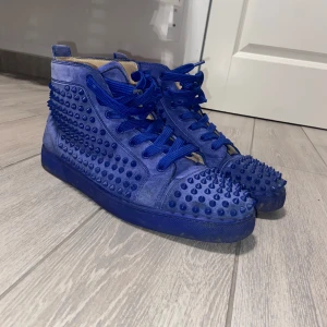 Christian Louboutin  - Ett par Snygga blå  Christian Loubitons sneakers med nitar över hela ytan. Använts en del men fortfarande i bra skick förutom lite innuti skorna, kan garantera äkthet men dock så finns inget kvitto eller bo.Skorna har snörning och en cool design som verkligen sticker ut. Perfekta för dig som vill ha något unikt i garderoben. Kan även byta mot andra skor eller något annat för samma pris. Hör av er vid fler funderingar!