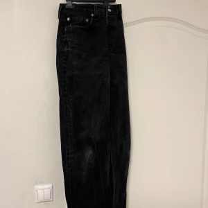 Svarta 501 jeans från Levi's - Snygga svarta Levi's 501 jeans med klassisk design. De har en rak passform och är tillverkade i slitstarkt denim. Perfekta för en stilren look med knappgylf och femficksmodell.