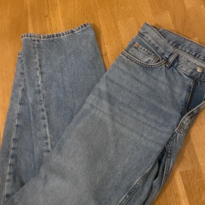 Blå jeansbyxor - Säljer ett par klassiska blå jeansbyxor med fickor och knappgylf. De har en rak/baggy passform och är perfekta för en avslappnad stil. Passar till det mesta och är ett måste i garderoben. 