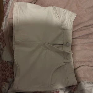 Vit kjol med dragkedja - Snygga vit kjol med dragkedja och knapp framtill. De har en klassisk design med fickor både fram och bak. Perfekta för en stilren look under varma dagar.