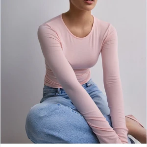 Ljusrosa långärmad topp - Säljer en stilren ljusrosa långärmad topp. Den har en tight passform och är tillverkad i ett mjukt material som ger en skön känsla mot huden. Perfekt för en enkel och snygg look. Storlek S, aldrig använd! 