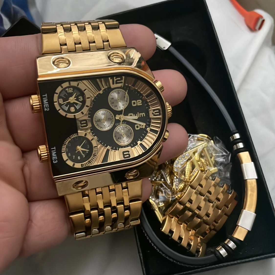 Guldfärgad klocka med länkarmband