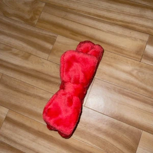 Rött diadem med rosett - Snyggt rött diadem i mjukt material med en söt rosett framtill.