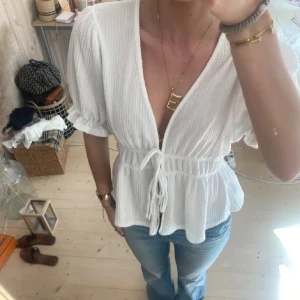 Vit blus med knytband - Säljer en söt vit blus med knytband i midjan och puffiga korta ärmar. Passar bra till jeans eller kjol. (Lånade bilder) 
