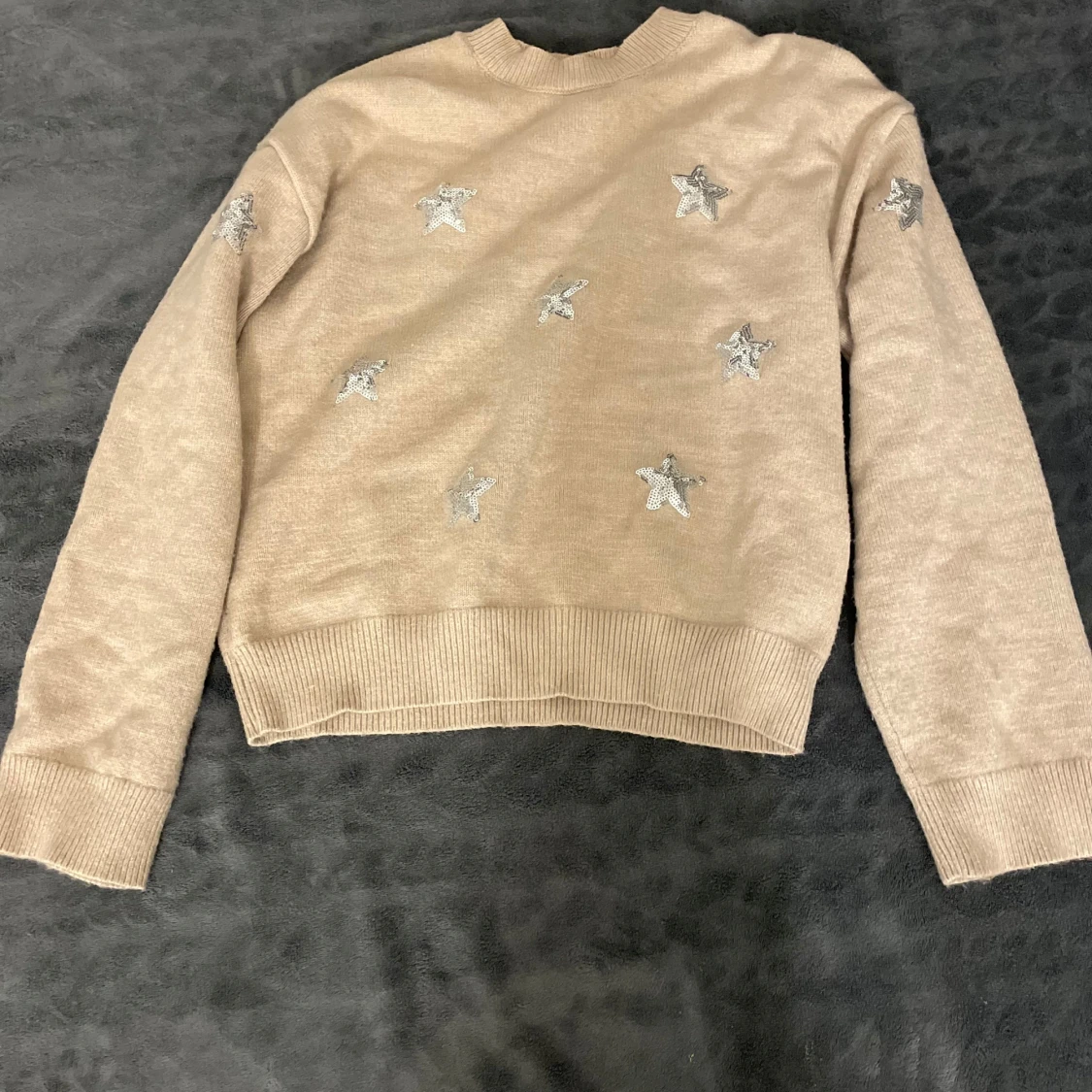 Beige tröja med stjärndetaljer