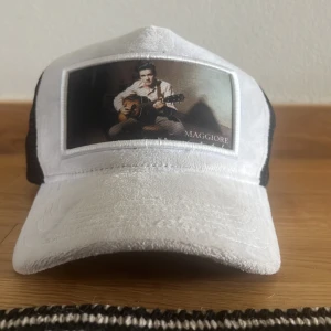 Maggiore keps - Snygg vit keps från Maggiore med en cool bild framtill. Kepsen har svart mesh på sidorna och baksidan för bra ventilation. Perfekt för en avslappnad stil. Kan gå ner i pris vid snabb affär 