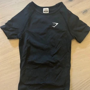 Seamless t-shirt från Gymshark - Säljer en helt perfekt svart t-shirt från Gymshark i storlek XS. Den formar sig jättefint efter kroppen🩷🩷🩷aldrig använd!!