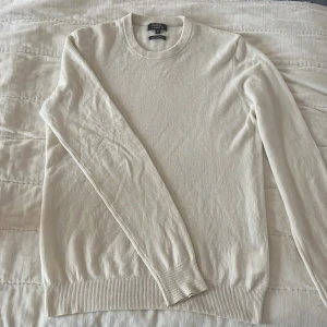 Vit kashmirtröja från Galeries Lafayette - Säljer en elegant vit kashmirtröja från Galeries Lafayette. Tröjan har en klassisk design med rund hals och långa ärmar. Perfekt för en stilren och bekväm look.